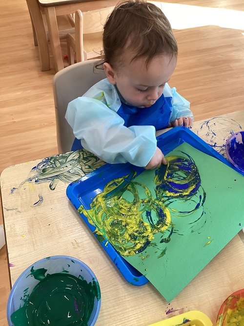 A child painting with a cup.