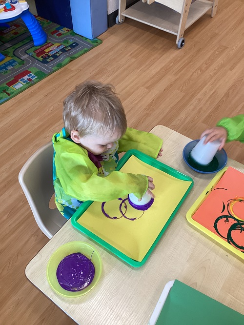 A child painting with a cup.