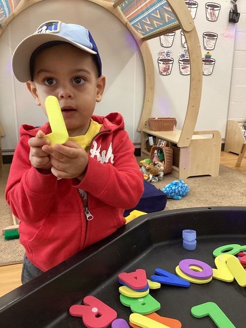 A child exploring with foam letters.