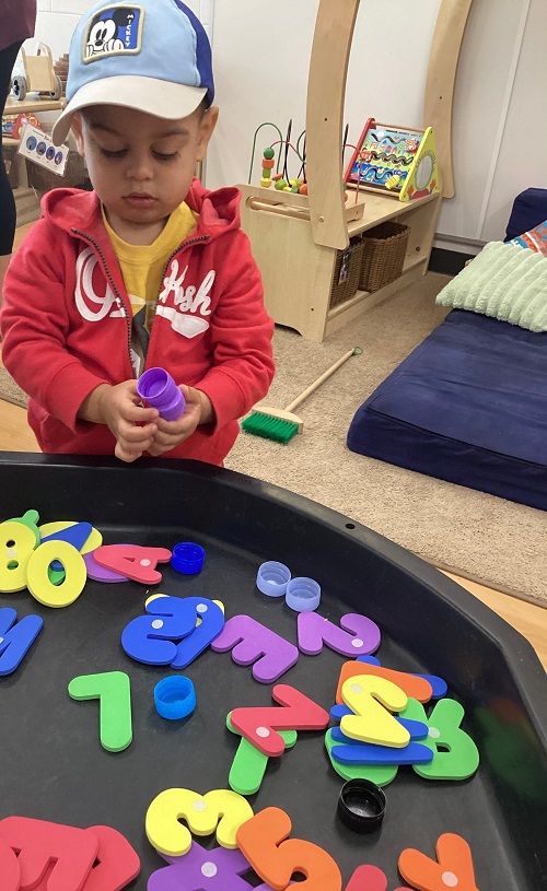 A child exploring with foam letters.