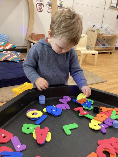 A child exploring with foam letters.