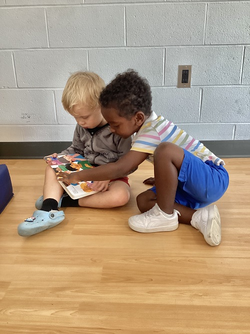 Two children looking at a book together.