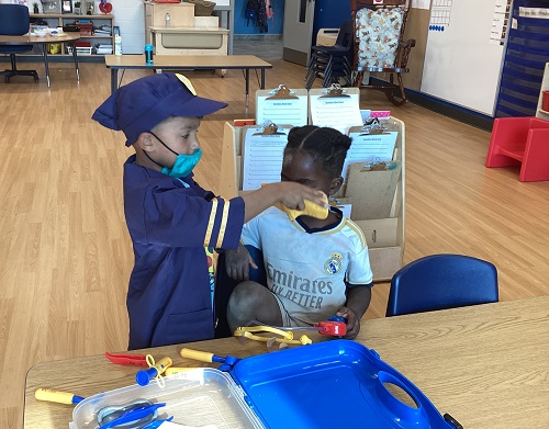 Two children engaging in dramatic play together.