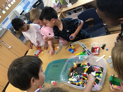 A group of children building lego at a table.