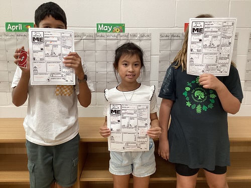 Three children holding up their "Getting to know you" sheet.