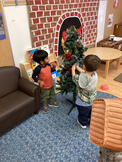 two children decorating a christmas tree