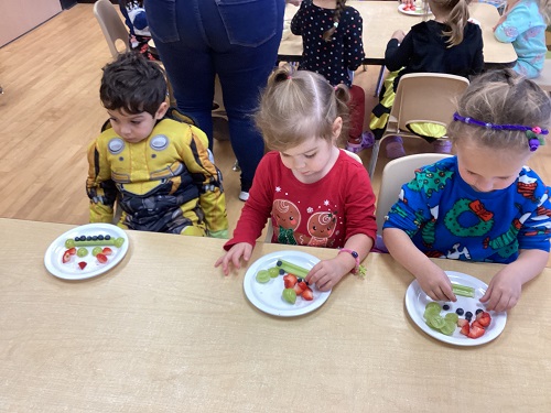 children at a table eating fruit
