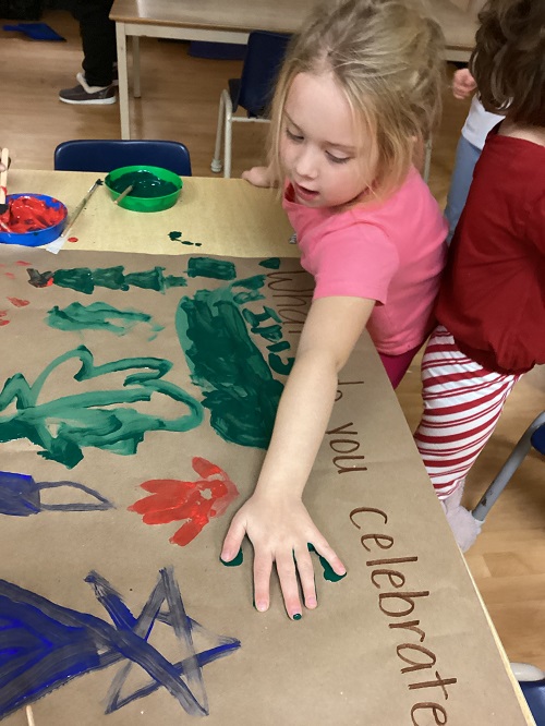 child putting a handprint on the painting