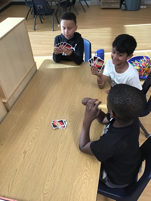 School age children playing a card game together 