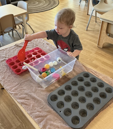 Toddler exploring scooping and dumping