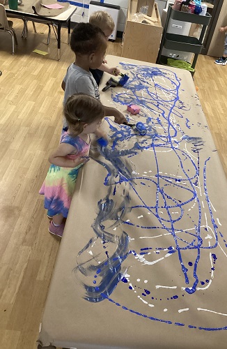 Toddlers painting together at table