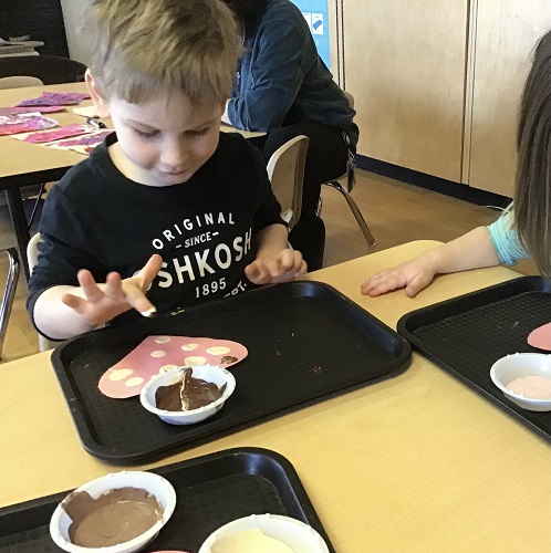 Child painting with skin tone colours