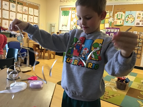 Child measuring length of ribbon