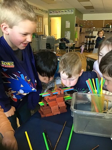 children trying to blow pig house down