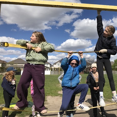 School-age children climbing on straps