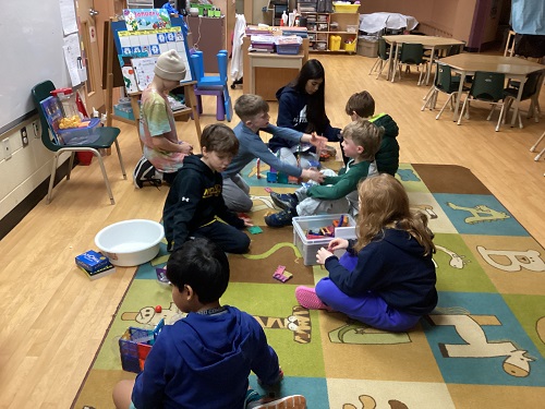 Group of school age children working together to build marble tracks