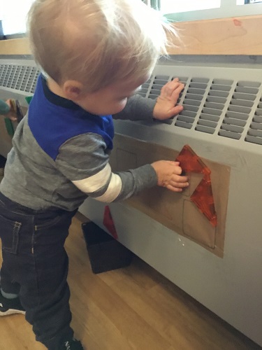 A child placing shape magnets on to the wall