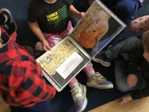 Children gathered around looking at a book