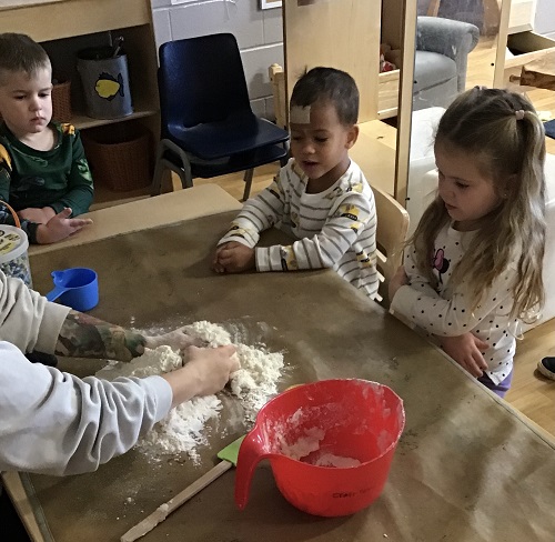 An educator and children around a table creating salt dough