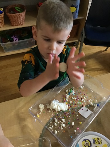 A child rolling a ball of salt dough in his hands