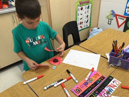 A child at a table creating paper poppies