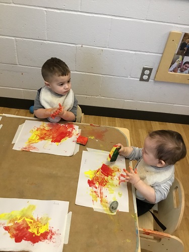 Two infants at the table painting 