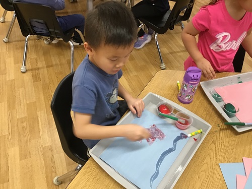 A child sitting at a desk painting