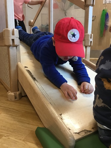 A child sliding down a ramp on his belly