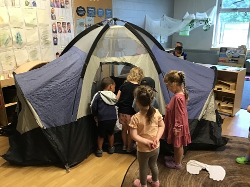 Children exploring a tent inside the classroom