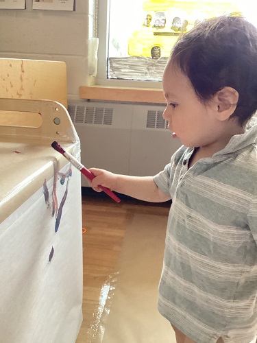 An infant painting on the shelf