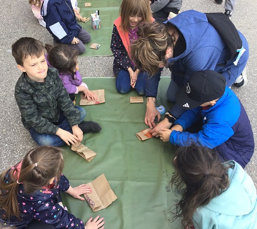 Children working our their Mother's Day crafts outside