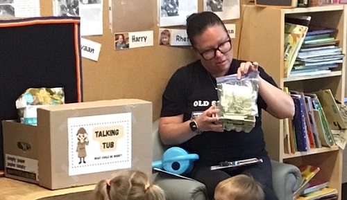 An educator showing the group the different seeds that have grown