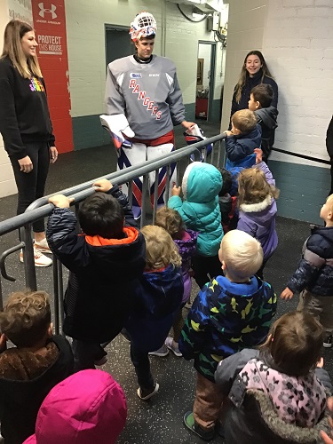 Children talking to a Hockey player
