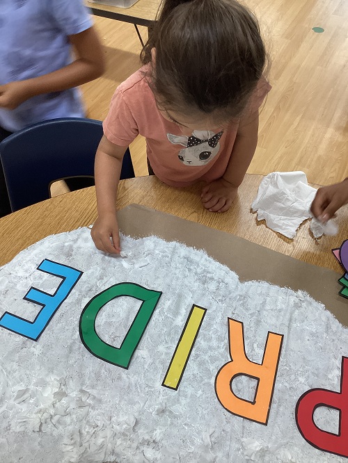 A school age child working on a Pride art project