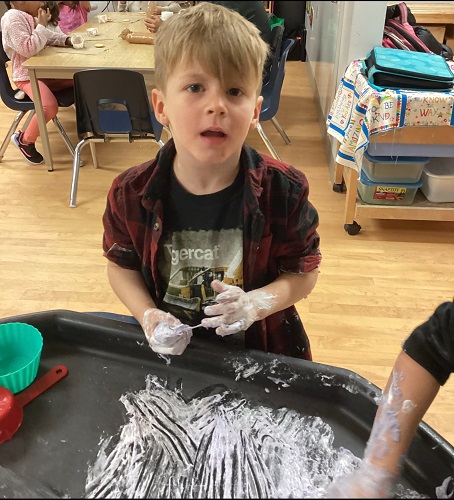 A child with flour on his hands
