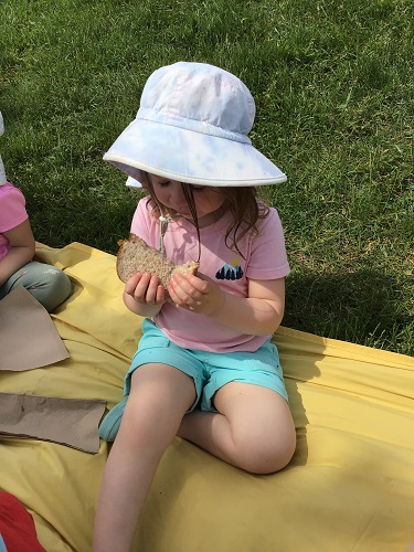 A child eating a sandwich at a picnic