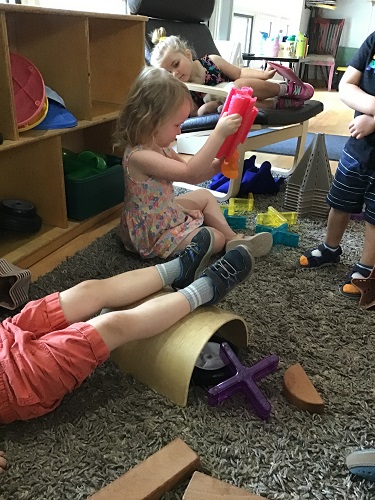 Several preschoolers are building rocket ships with various loose parts.