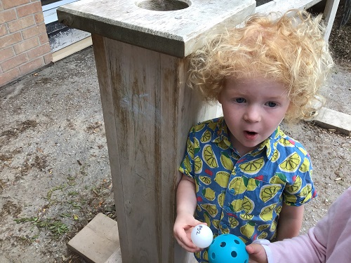 child holding two balls