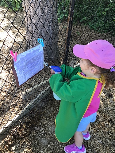 child sprays paper with water paints