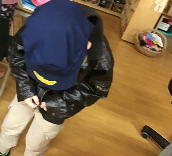 School-age boy wearing hat and jacket for dress up