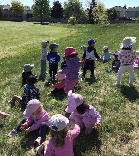 all preschool cutting grass in field