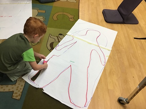 school-age boy decorating  body shape 