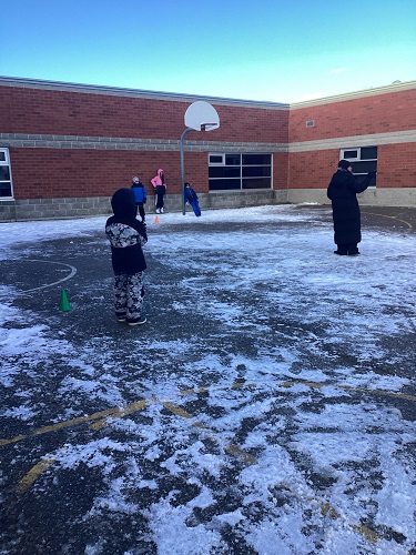 Group of school-age children playing soccer baseball
