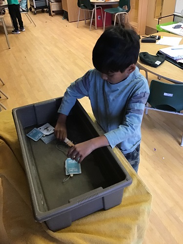JKK boy making boat out of supplies
