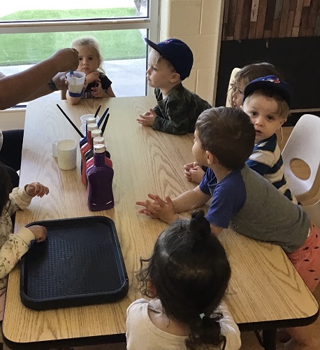 Toddlers exploring paint and turf 