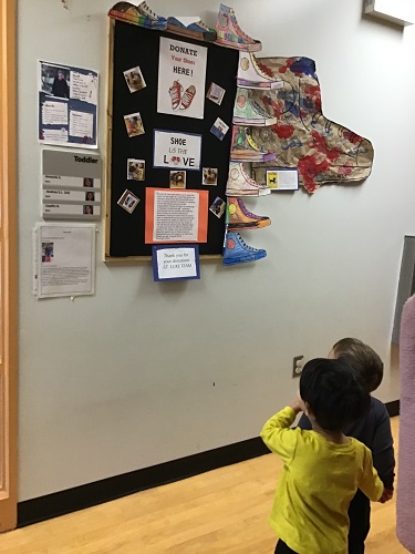 Toddler children noticing shoes on wall 