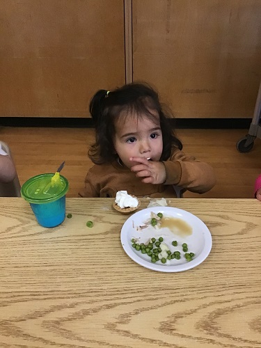 toddler girl enjoying thanksgiving dinner for lunch 