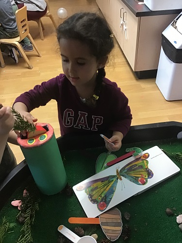Preschool girl feed hungry caterpillar 