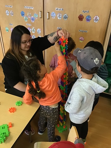 Children building gears with educator 
