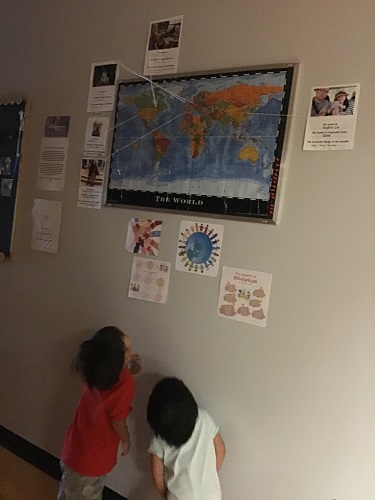 2 preschool children looking at map on wall